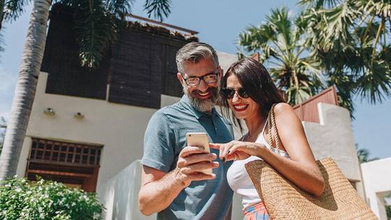 couple-using-their-phone-while-on-vacation-24R58HF